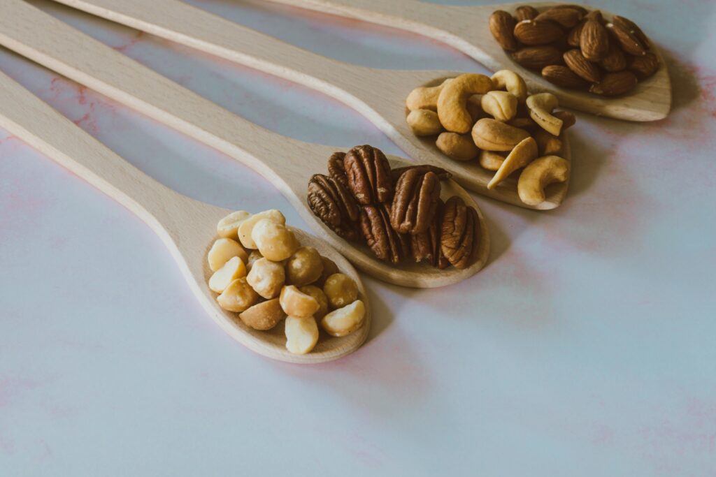 Various nuts arranged on wooden spoons for a natural and nutritious look.
